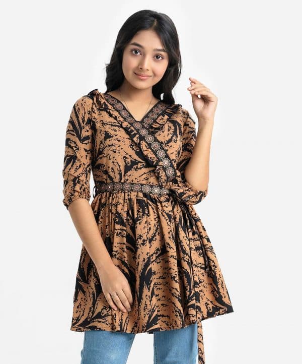 Teen girl's frock-style tunic in printed georgette fabric. Puff sleeves, retro wrap collar with frill trims. Karchupi and gathered at the front. A belt.