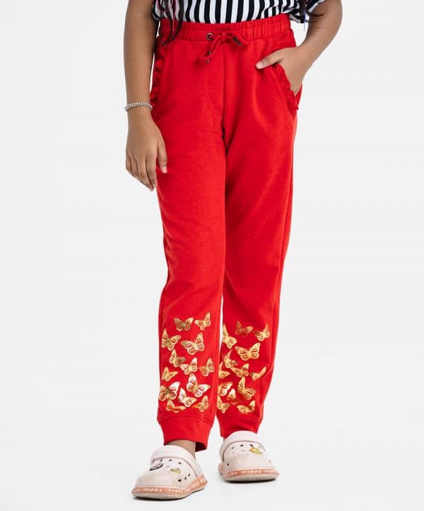 Kid girl's sweat pant in interlock knit fabric.Concealed elasticated waistline with adjustable drawstring. Two side pockets with frill trims and a back pocket. Butterfly printed.