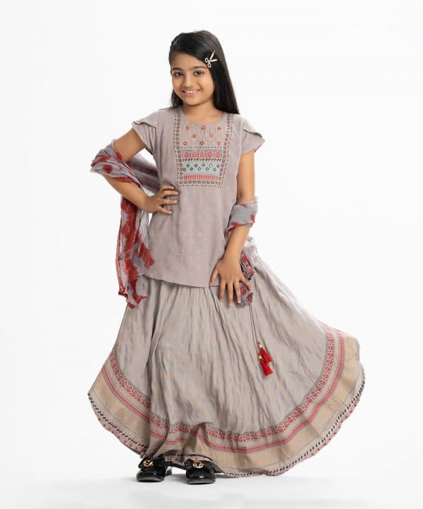 Kid girls printed ghagra choli set in viscose fabric. Round neck, short-sleeved top with karchupi at the front. Tie-dye chiffon dupatta with a printed skirt.