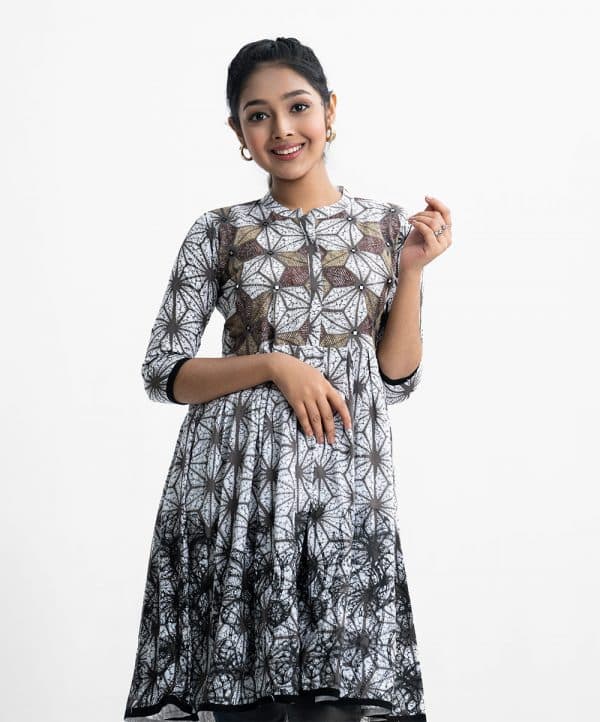 Teen girl printed A-line tunic in viscose fabric. Stand collar, three-quarter sleeved. Gathered at the waistline and embroidery at the front.