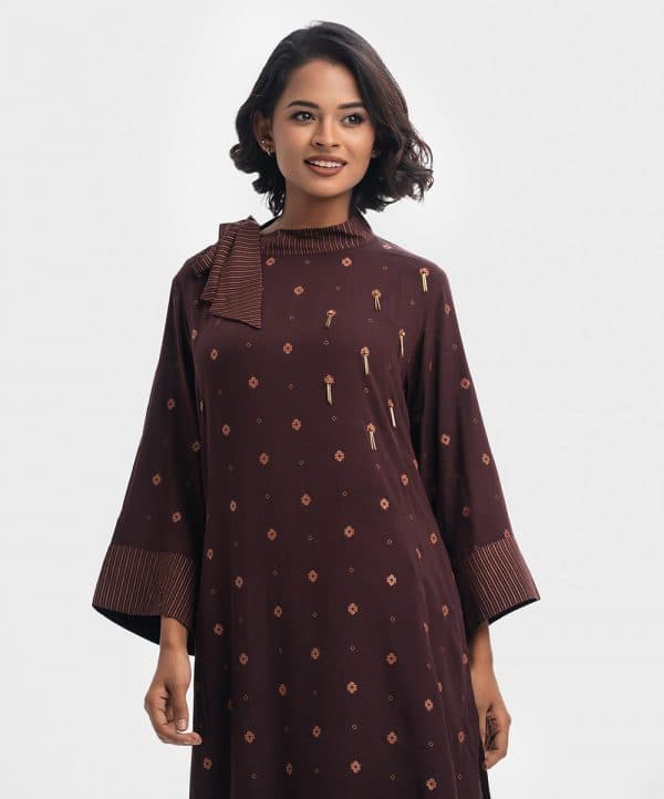 High-neck tunic in viscose fabric. Tie-knot and snap button opening over the shoulder. Inseam side pockets with a high-low hemline. Bell sleeved.